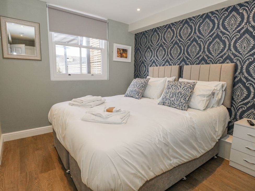 A bedroom with a double bed and wall art at Vista Mare 1 in Weymouth