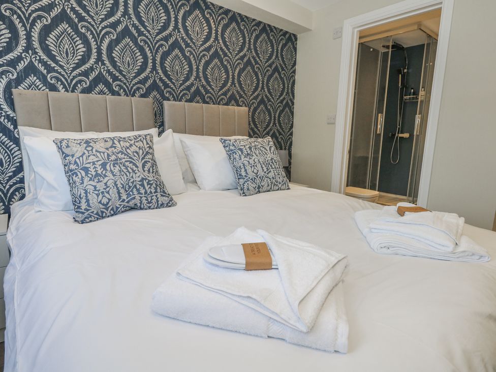 A bedroom with a bed and a shower area at Vista Mare 1 Weymouth