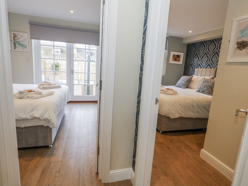 Two bedrooms with beds and towels at Vista Mare 1 Weymouth