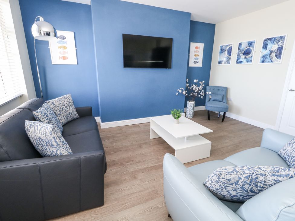 A living room with a sofa and television at Apartment 2 in Weymouth