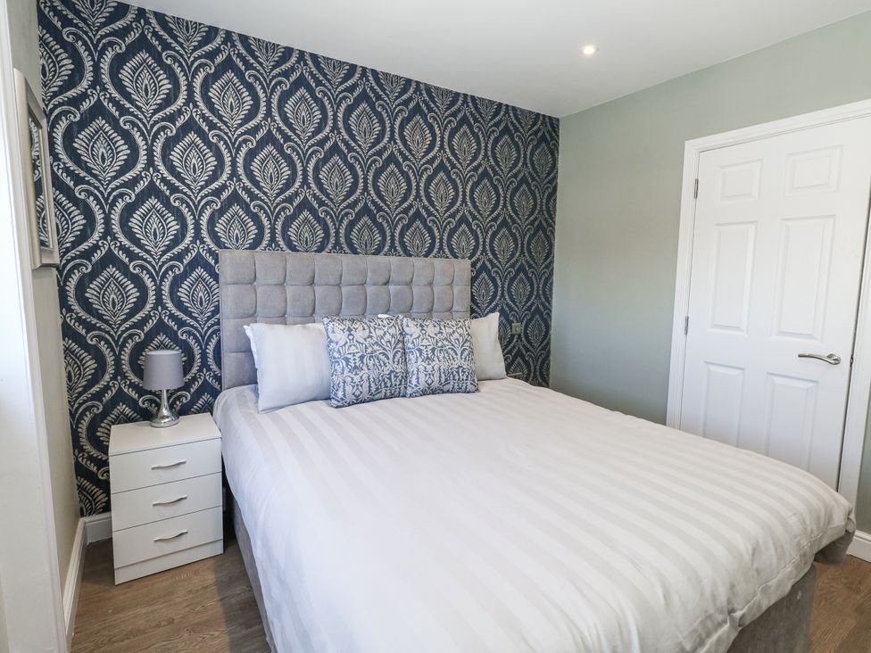 A bedroom with a bed and bedside table at Apartment 2 in Weymouth