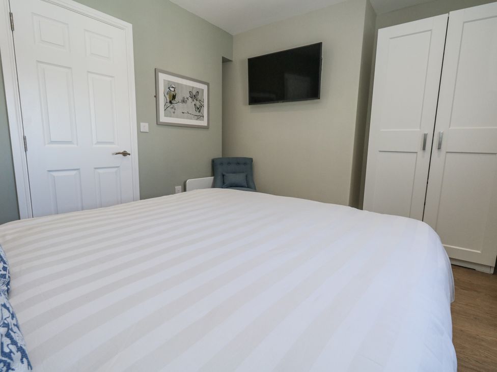A bedroom with a bed and wardrobe at Apartment 2 in Weymouth
