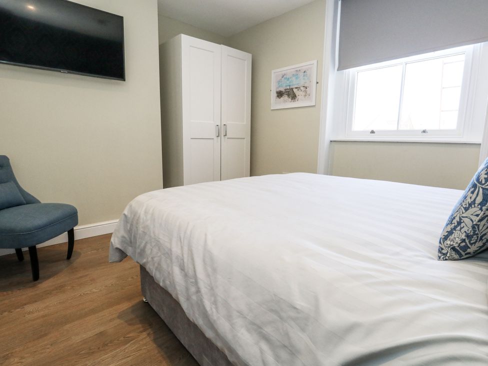 A bedroom with a bed and television at Apartment 2 Weymouth