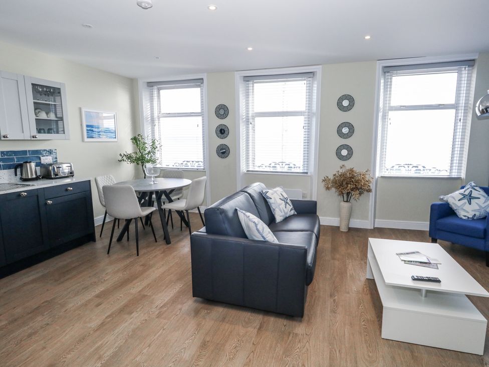 A living room with a sofa and dining table at Vista Mare 2 in Weymouth