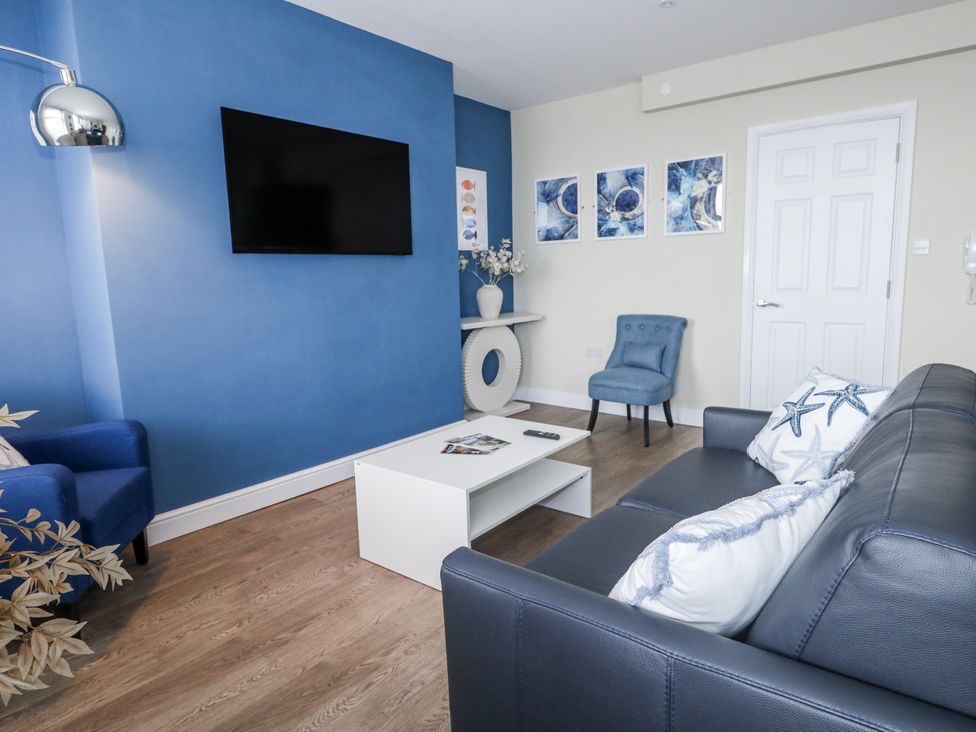 A living room with a television on the wall at Vista Mare 2 in Weymouth