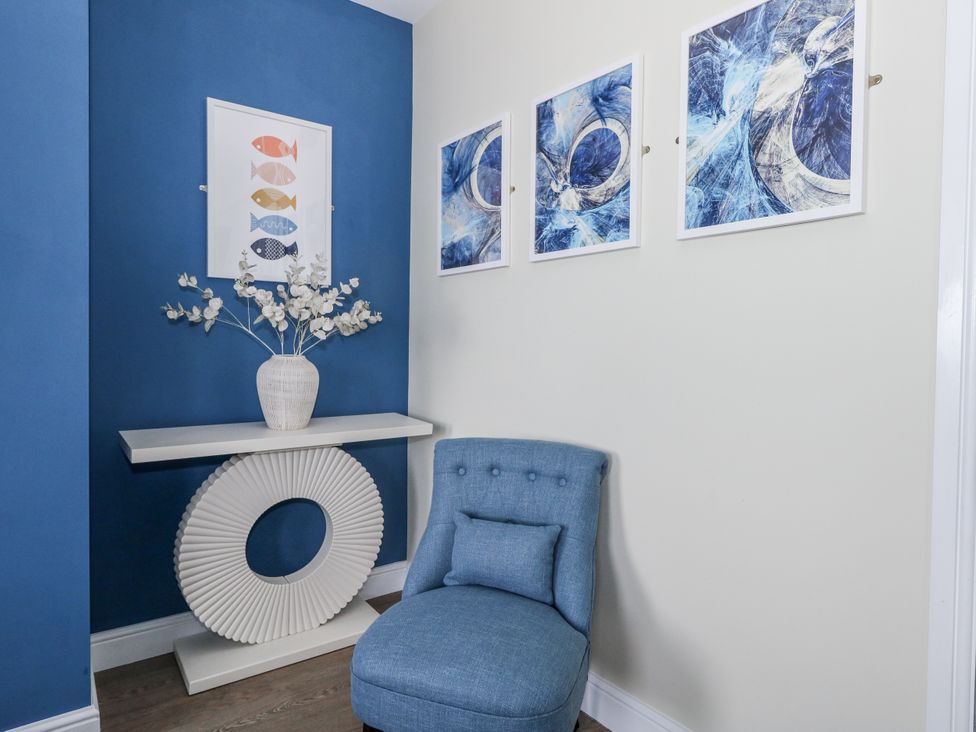 A hallway with a console table and chair at Vista Mare 2 Weymouth