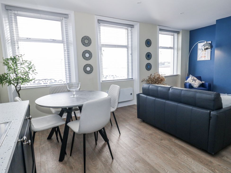 A living room with a dining table and sofa at Vista Mare 2 in Weymouth