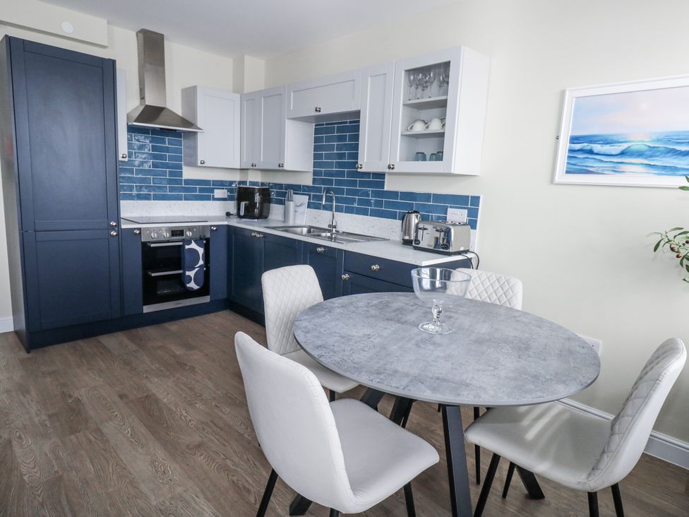 A kitchen with a table and chairs at Vista Mare 2 in Weymouth