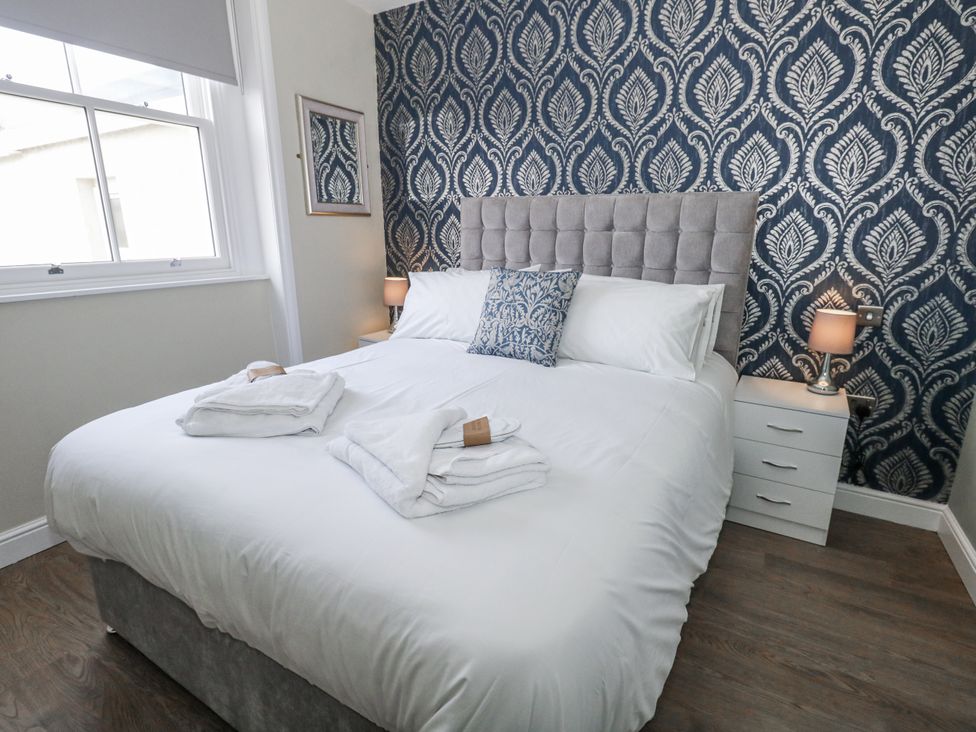 A bedroom with a bed and bedside table at Vista Mare 2 Weymouth