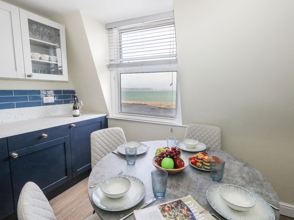 A kitchen with a dining table and chairs at Apartment 3 in Weymouth