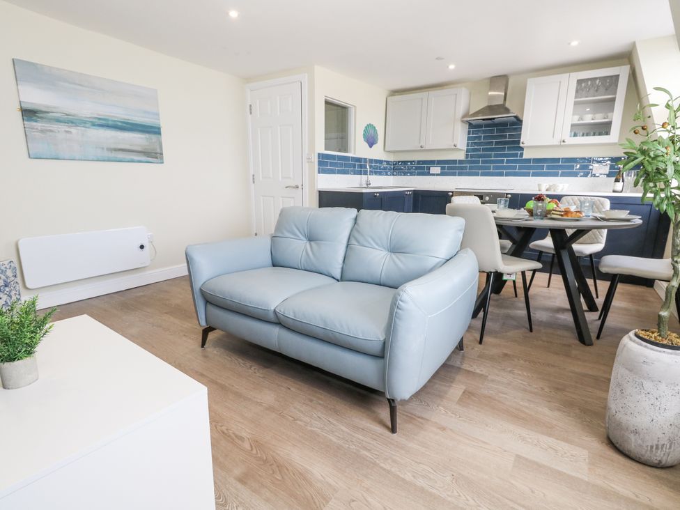 A living room with a sofa and dining area at Apartment 3 in Weymouth