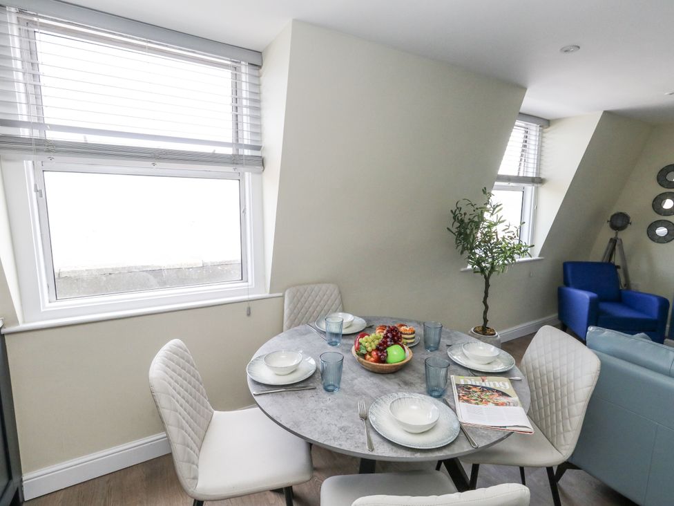 A dining room with a table set for a meal at Apartment 3 in Weymouth