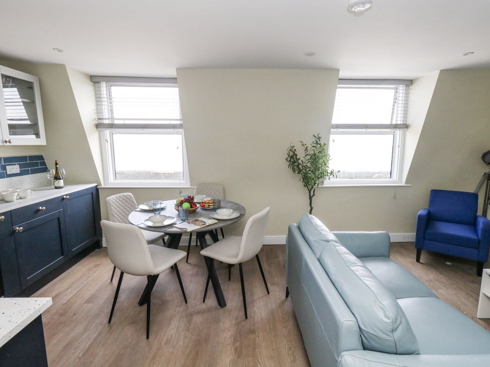 A living room with a table and chairs and a sofa at Apartment 3 Weymouth