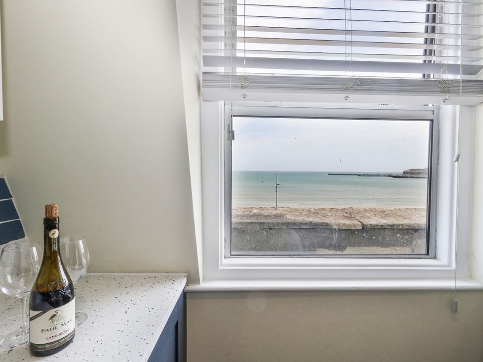 A kitchen with a view of the sea and pier at Apartment 3 Weymouth