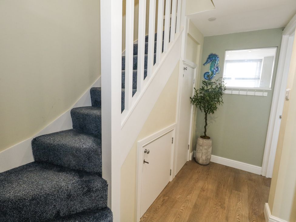 A hallway with stairs and a plant at Apartment 3 in Weymouth