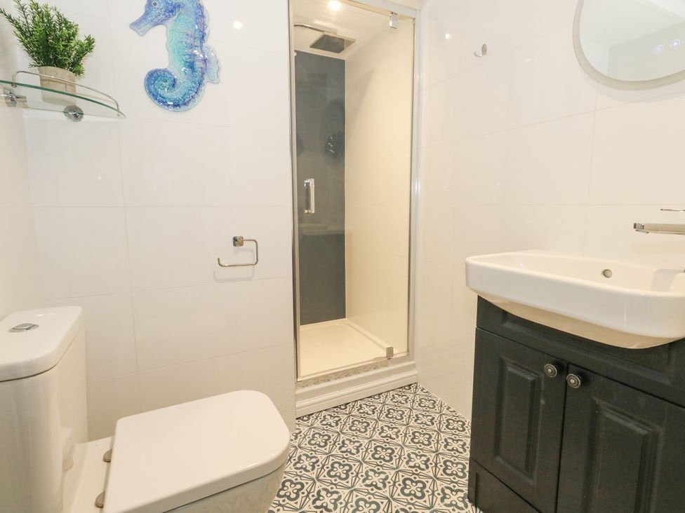 A bathroom with a sink, shower, and toilet at Apartment 3 in Weymouth