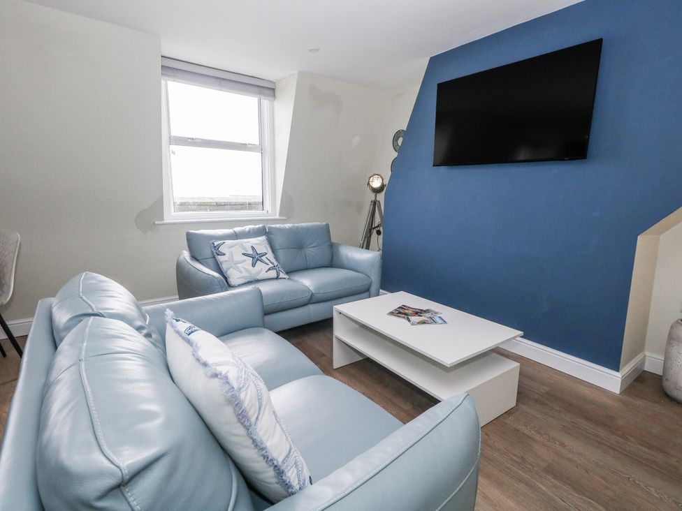 A living room with a sofa and television at Vista Mare 3 in Weymouth