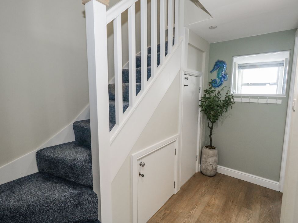 A hallway with a staircase and a plant at Vista Mare 3 Weymouth
