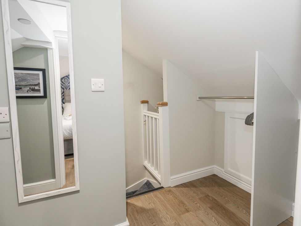 A hallway with a mirror and stairs at Vista Mare 3 in Weymouth