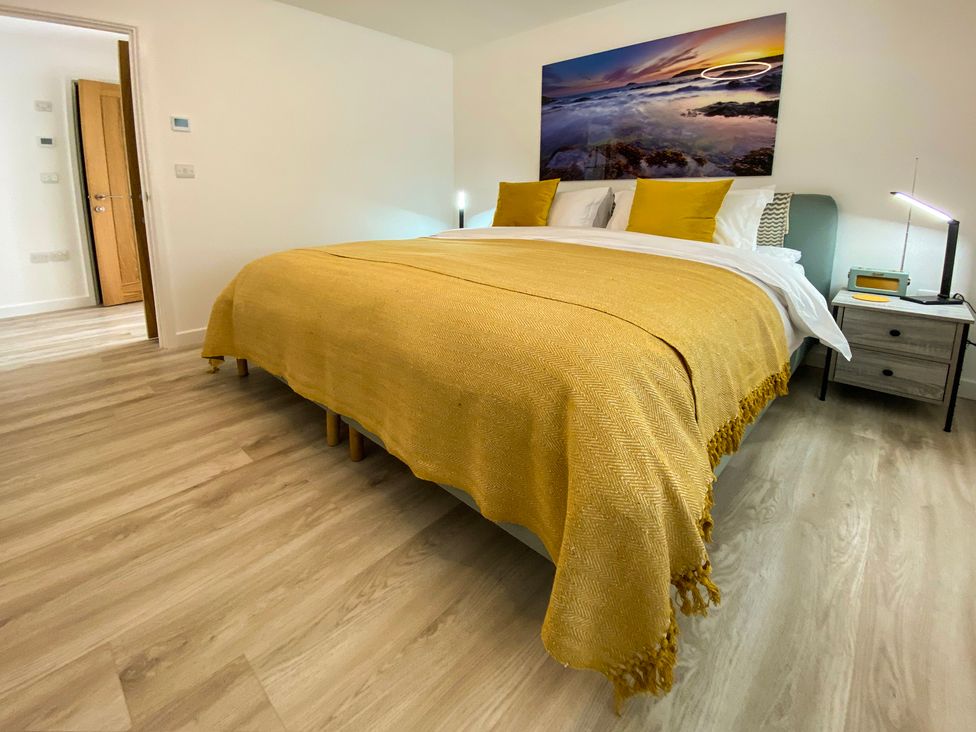 A bedroom with a bed and bedside table at Sandwood Studios in Crantock