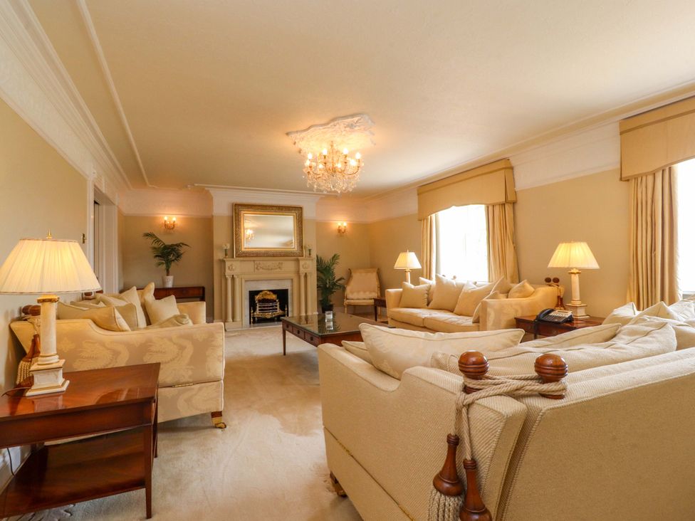 A living room with a sofa, armchairs, and a fireplace at Laithe House in Burnley