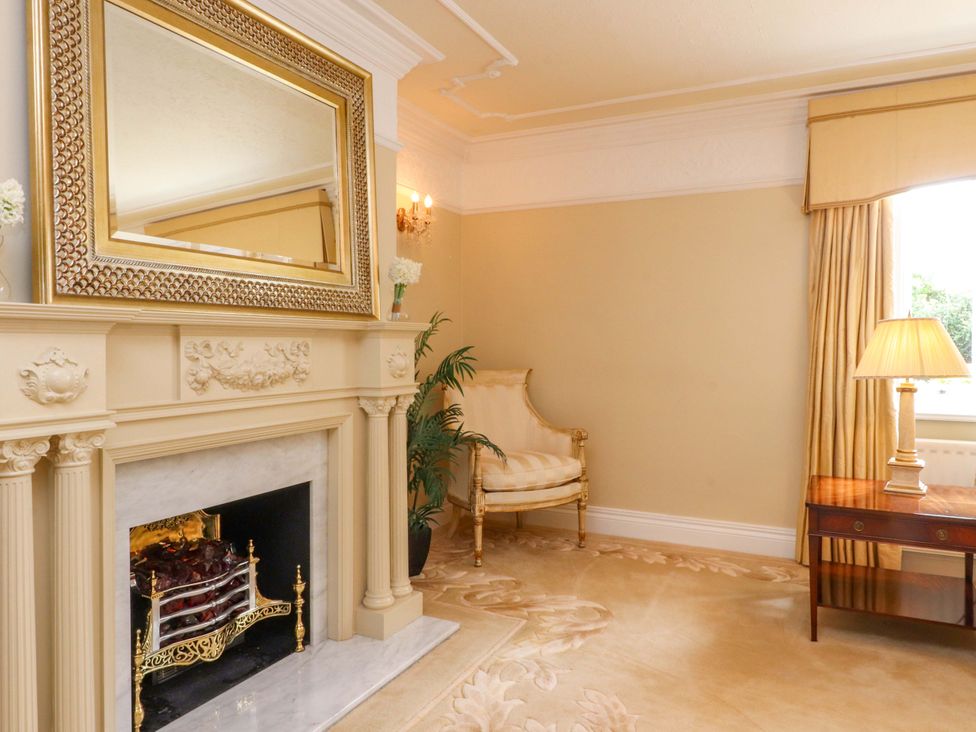 A living room with a fireplace and armchair at Laithe House in Burnley