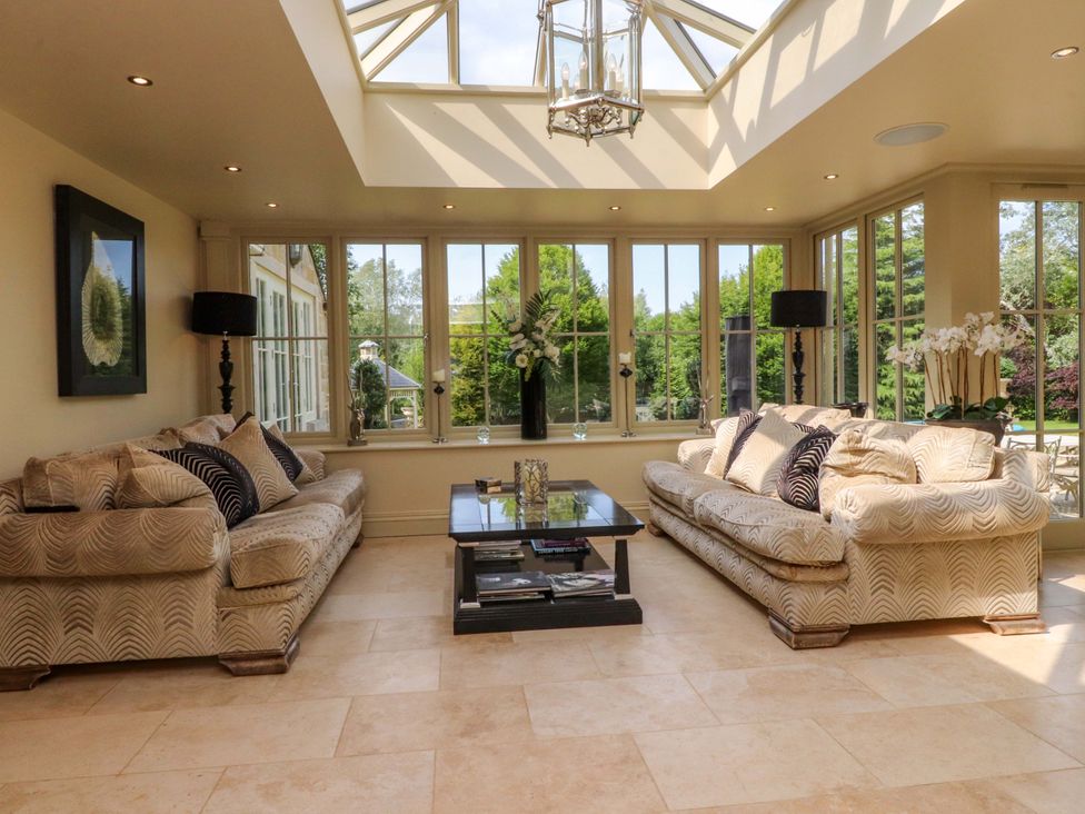A conservatory with sofas and a coffee table at Laithe House in Burnley