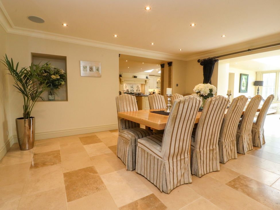 A dining room with a long table and chairs at Laithe House in Burnley