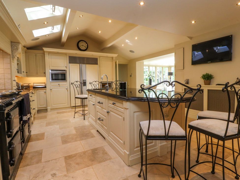 A kitchen with a large island and bar stools at Laithe House in Burnley