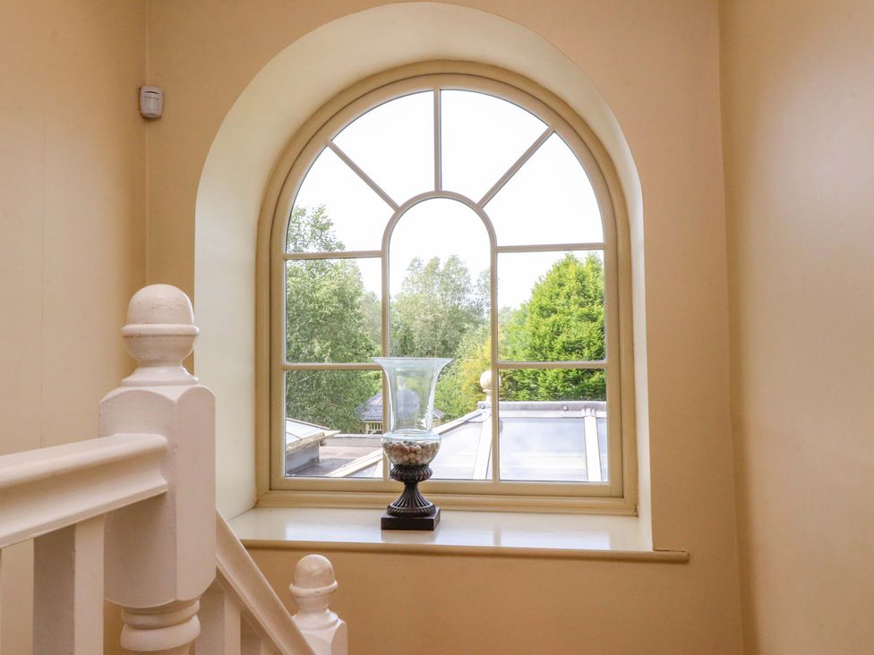 A staircase with a window and vase at Laithe House Burnley