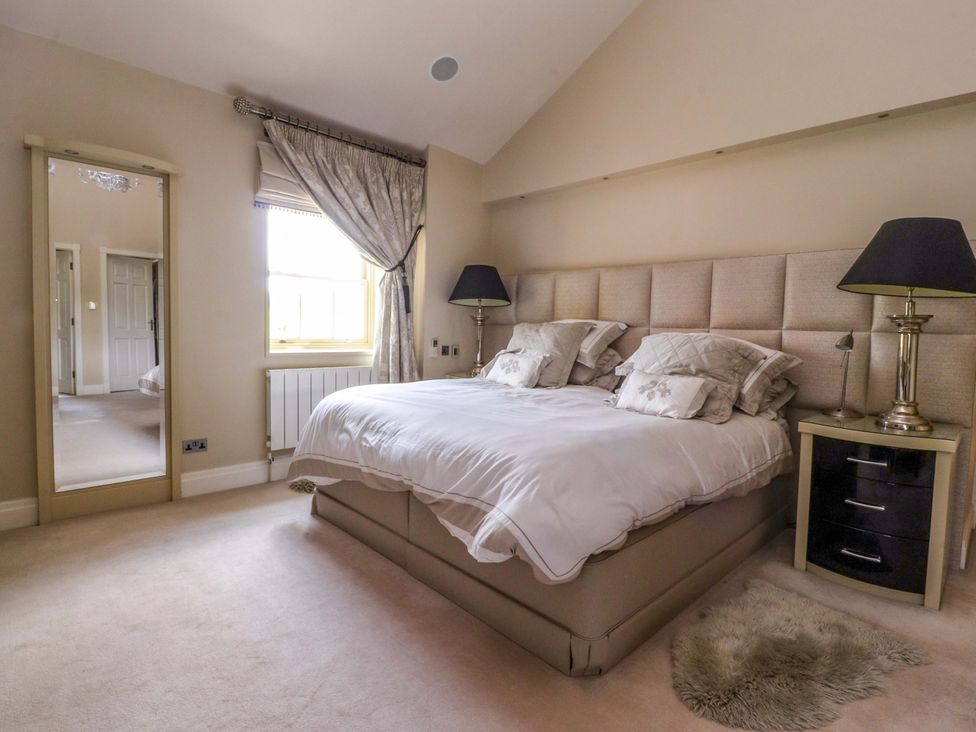 A bedroom with a bed and a mirror at Laithe House in Burnley