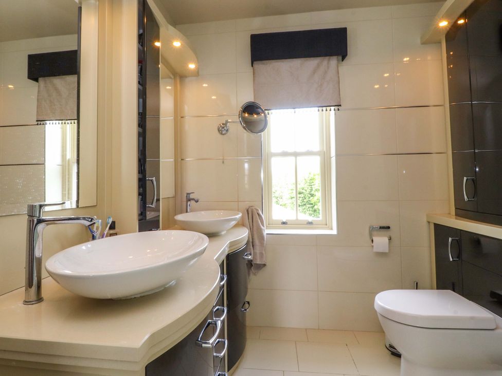 A bathroom with sinks and a window at Laithe House in Burnley