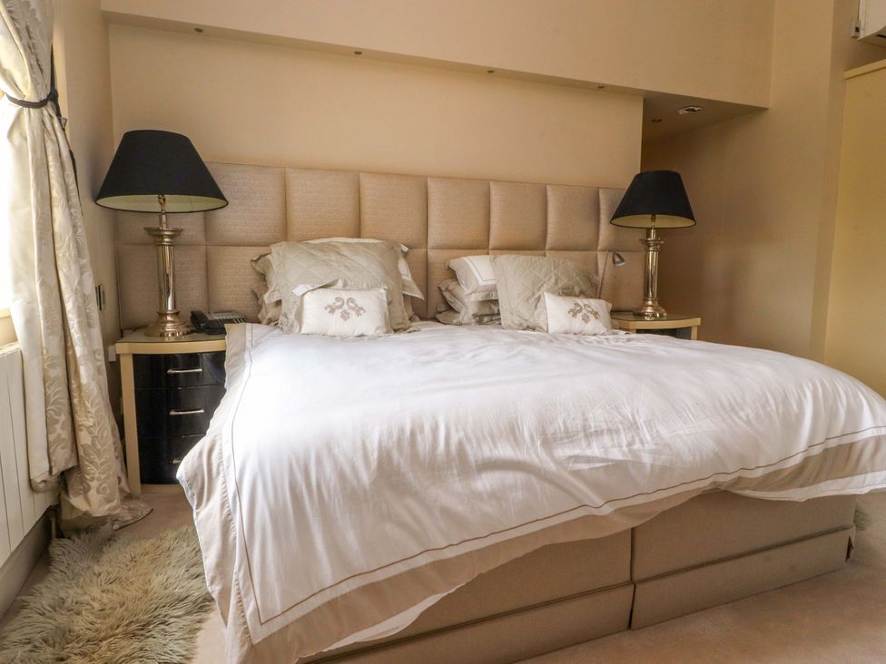 A bedroom featuring a bed with pillows and side lamps at Laithe House in Burnley