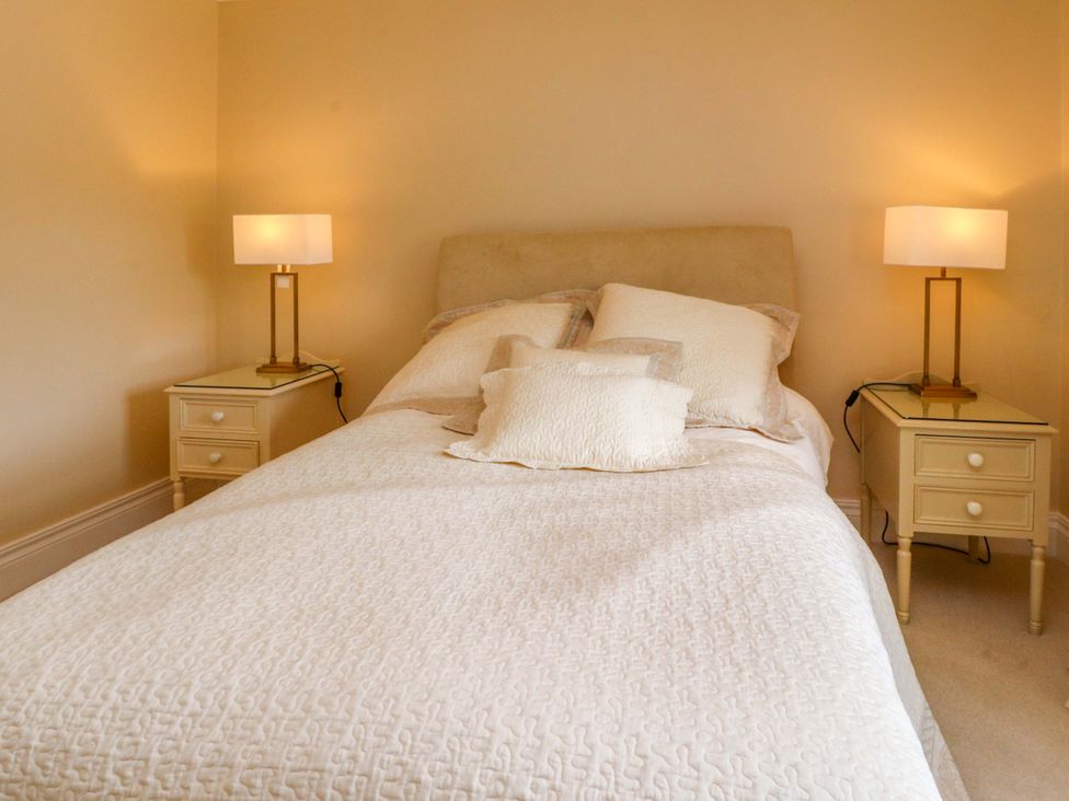 A bedroom with a bed and bedside tables with lamps at Laithe House Burnley