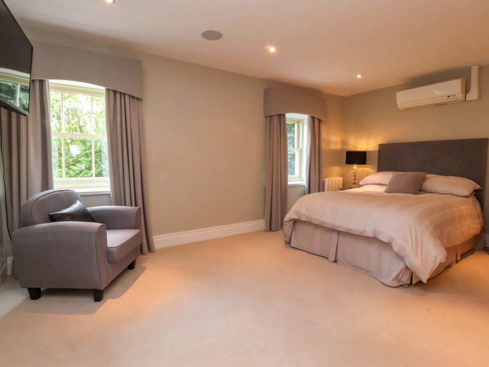 A bedroom with a bed and an armchair at Laithe House in Burnley