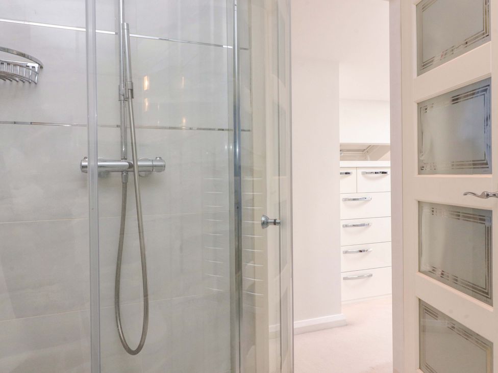 A bathroom with a glass shower enclosure and a drawer unit at Laithe House in Burnley