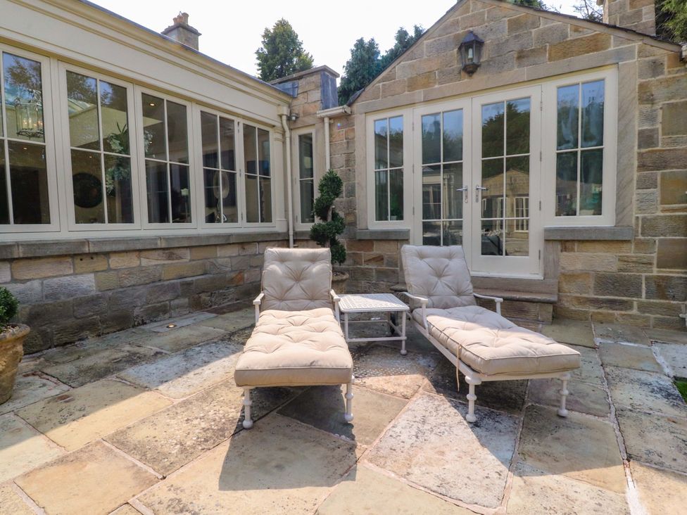 An outdoor area with lounge chairs and a coffee table at Laithe House Burnley