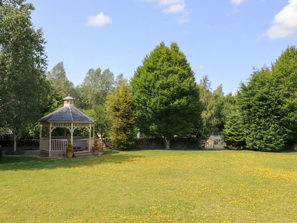 A garden with a gazebo and trees at Laithe House Burnley