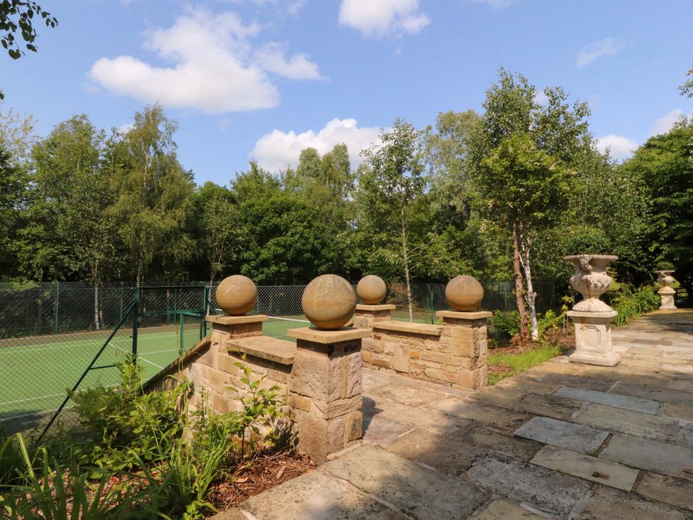A garden with a stone wall and decorative spheres at Laithe House in Burnley