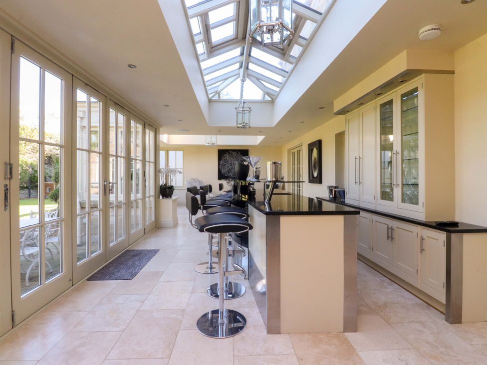 A kitchen with a skylight and bar stools at Laithe House in Cliviger