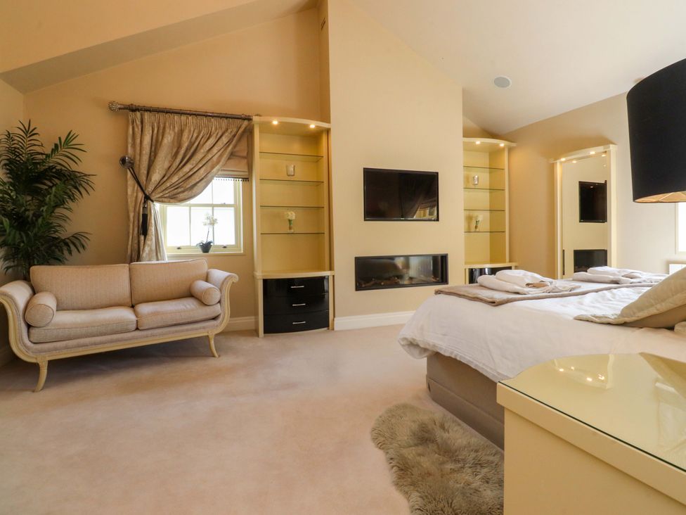 A bedroom with a bed, sofa and television at Laithe House in Cliviger