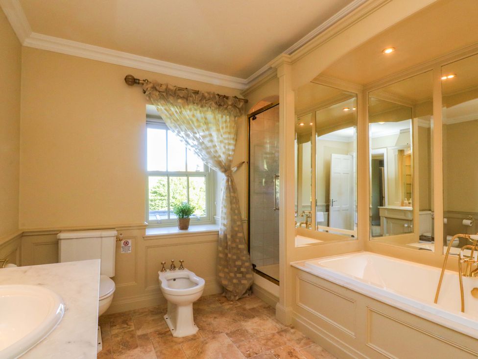 A bathroom with a bathtub, shower, sink, and toilet at Laithe House Cliviger
