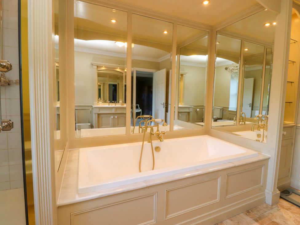 A bathroom featuring a bathtub with mirrors at Laithe House in Cliviger