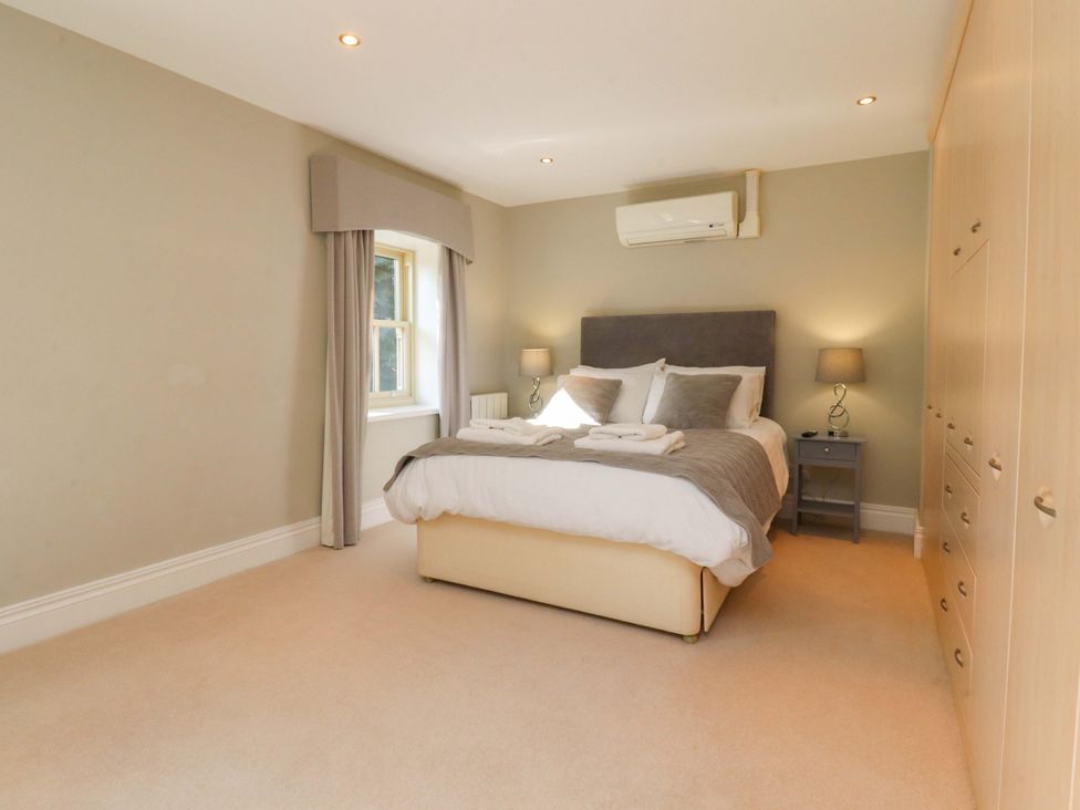 A bedroom with a bed and bedside tables at Laithe House Cliviger