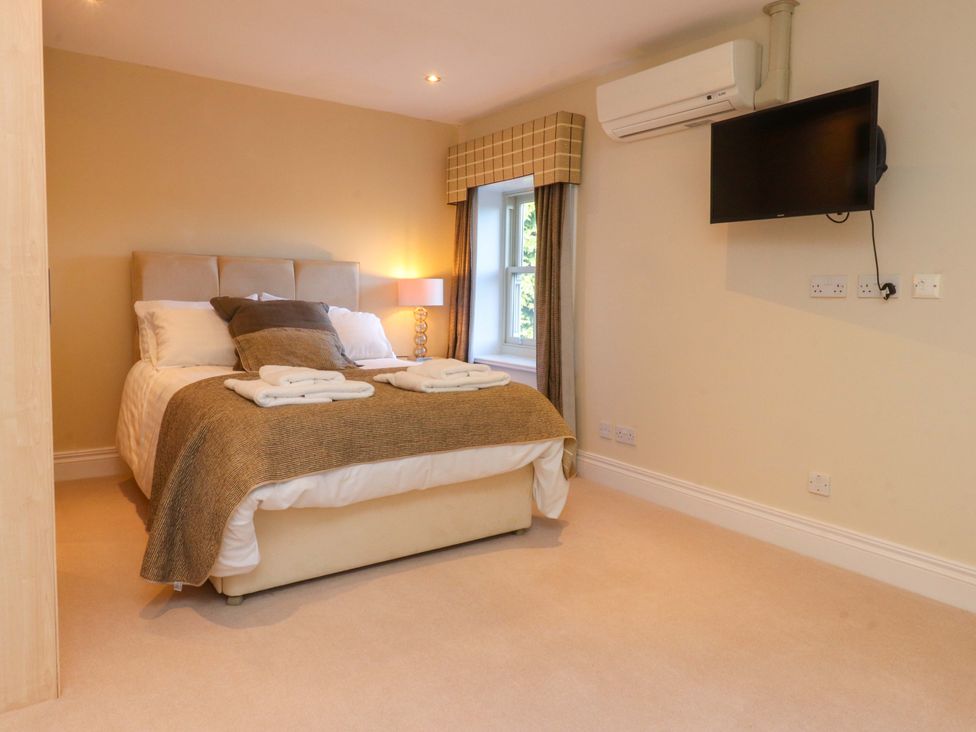 A bedroom with a bed and television at Laithe House Cliviger