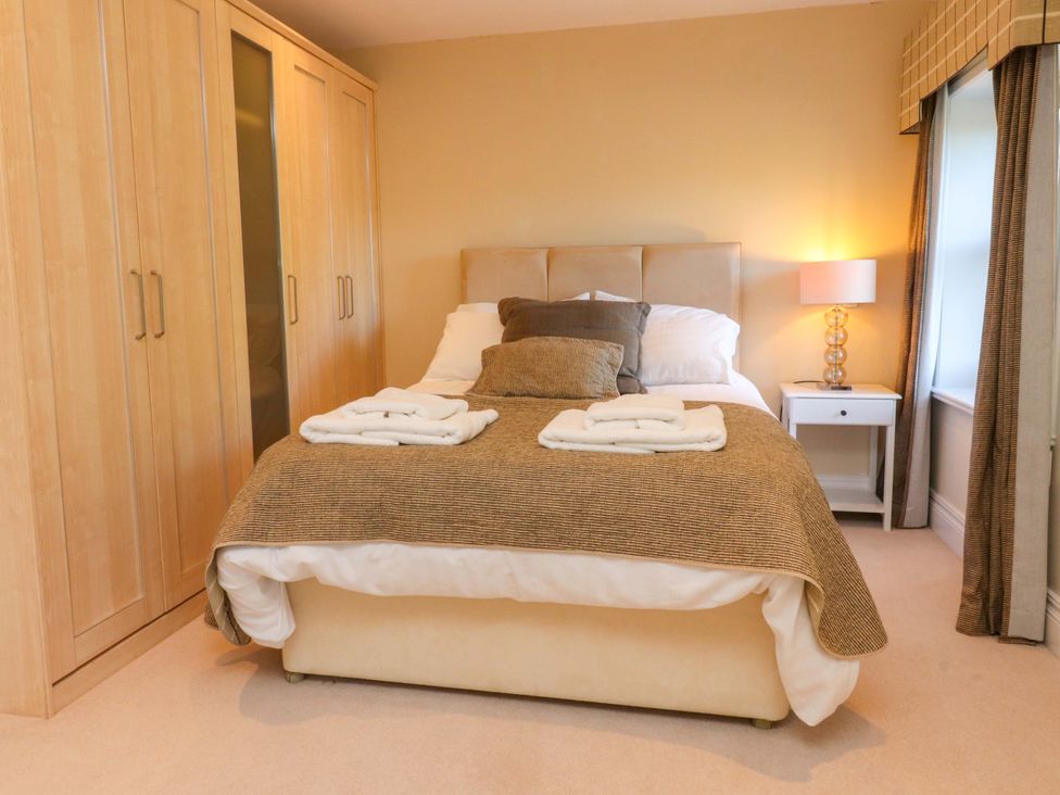 A bedroom with a bed and wardrobe at Laithe House in Cliviger