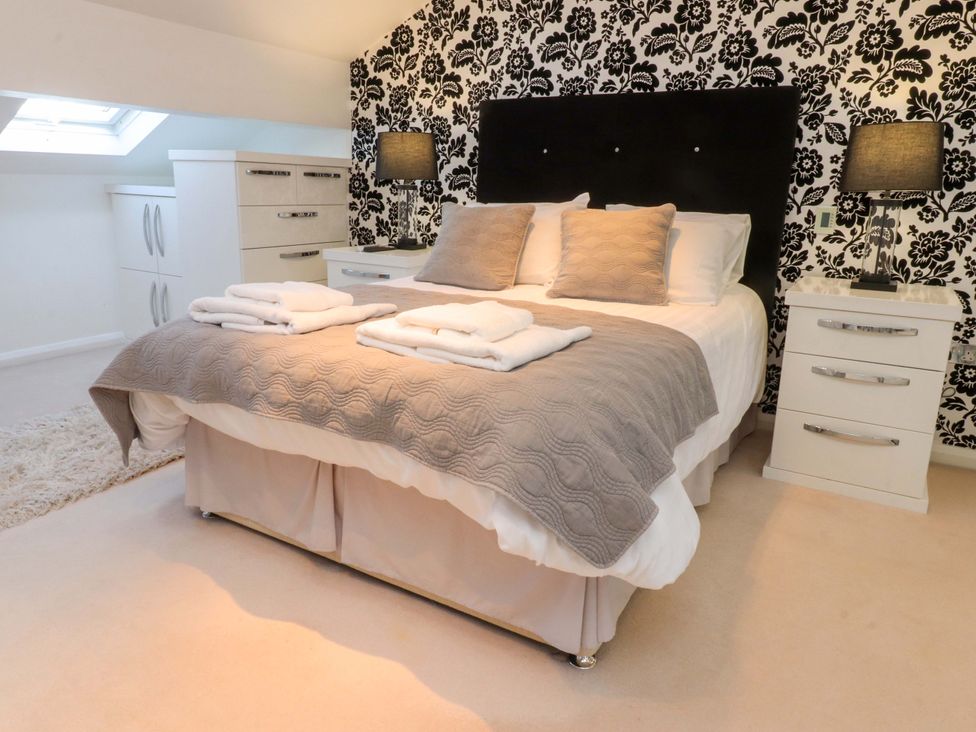 A bedroom with a bed and bedside tables at Laithe House in Cliviger