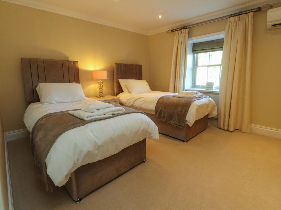 A bedroom with two beds and a window at Laithe House Cliviger