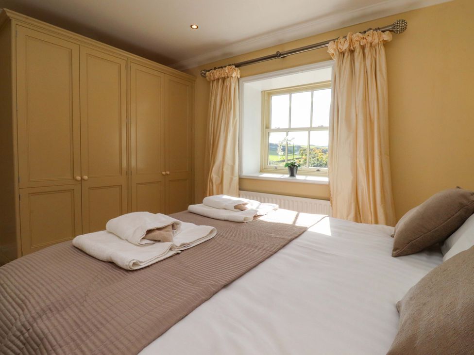 A bedroom with a bed and wardrobe at Laithe House Cliviger