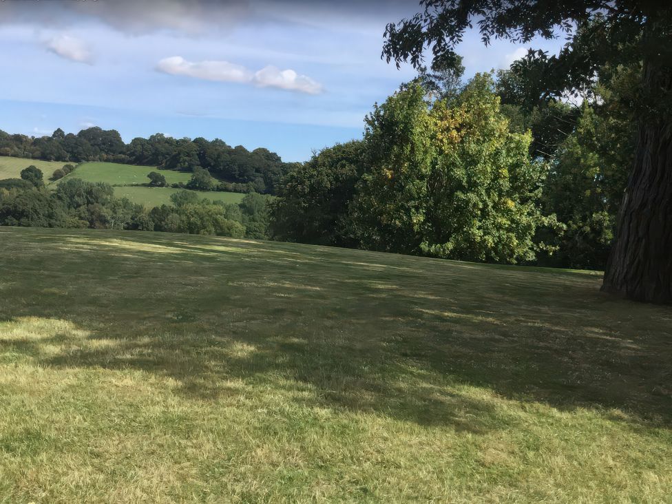 A grassy area with trees and hills at Upper Home Farm